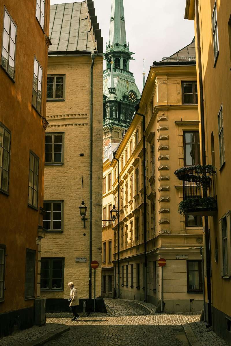 Calle estrecha en Gamla Stan (Ciudad Vieja) de Estocolmo, Suecia, con la distintiva aguja de la Iglesia Alemana