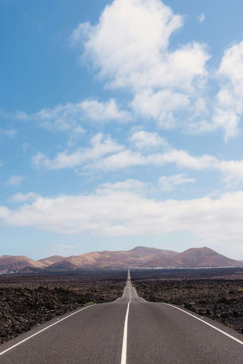 Carretera que atraviesa un paisaje volcánico en la isla de Lanzarote